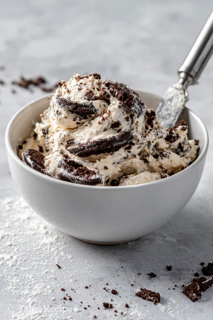 Mixing bowl with Oreo cupcakes batter swirled with crushed Oreos.