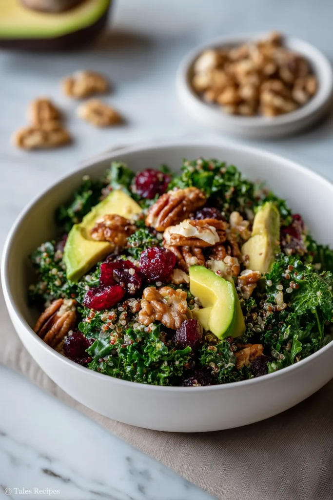Featured superfood salad with kale, quinoa, avocado, nuts, and berries on white marble background.